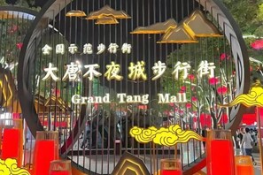 Uma placa com o texto 'Grand Tang Mall' e elementos decorativos.