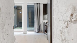 Un intérieur moderne au design minimaliste, avec une grande fenêtre, un escalier et un espace salle de bain visible.