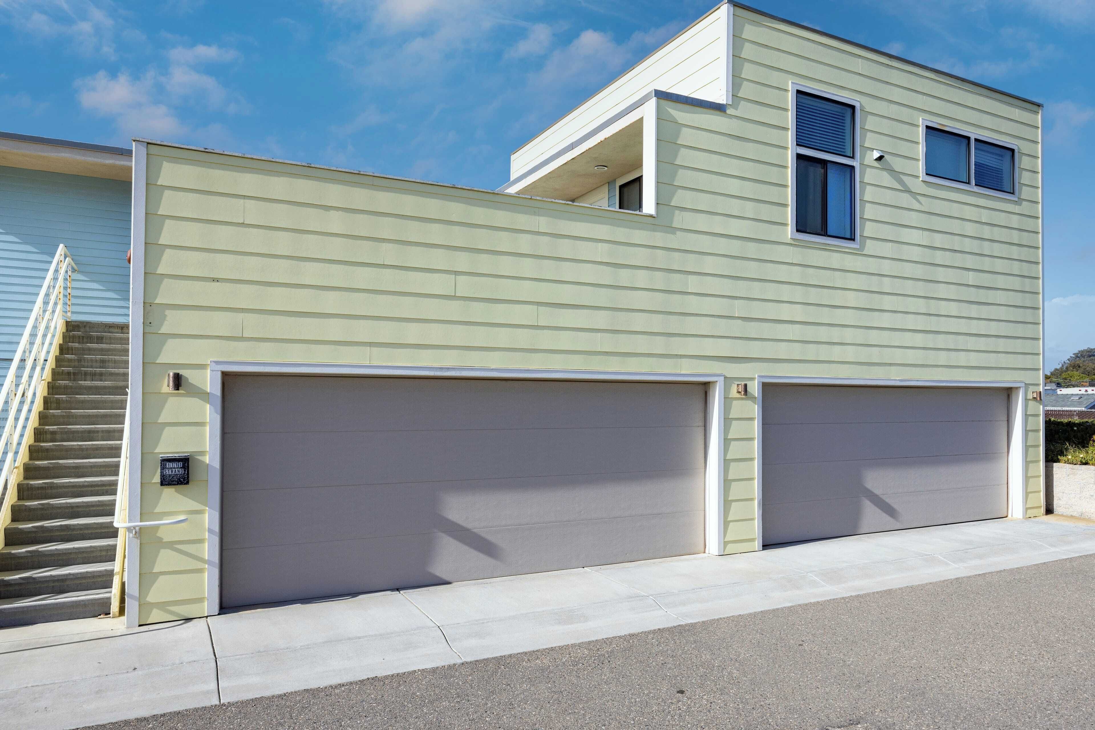 A two-story house with a garage, a staircase to the left, and a clear sky.