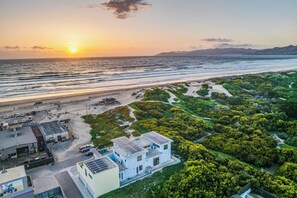 A coastal area with a beach, a parking lot, and a building with solar panels. - 2 Oceanfront Homes w/ Rooftop Deck, Views & Steps to the Sand (Oceano)