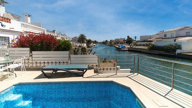 Una piscina con vistas a un canal y edificios al fondo.