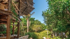 A pool area with a wooden deck, seating, and a pergola structure. - Terrazza Trancoso Hotel Boutique (Porto Seguro)