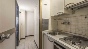 A compact kitchen with a stove, sink, and tiled backsplash. - Le Petit BSJ By MMega (Florence)