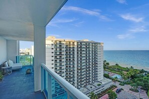 A high-rise building with balconies overlooking a beach.