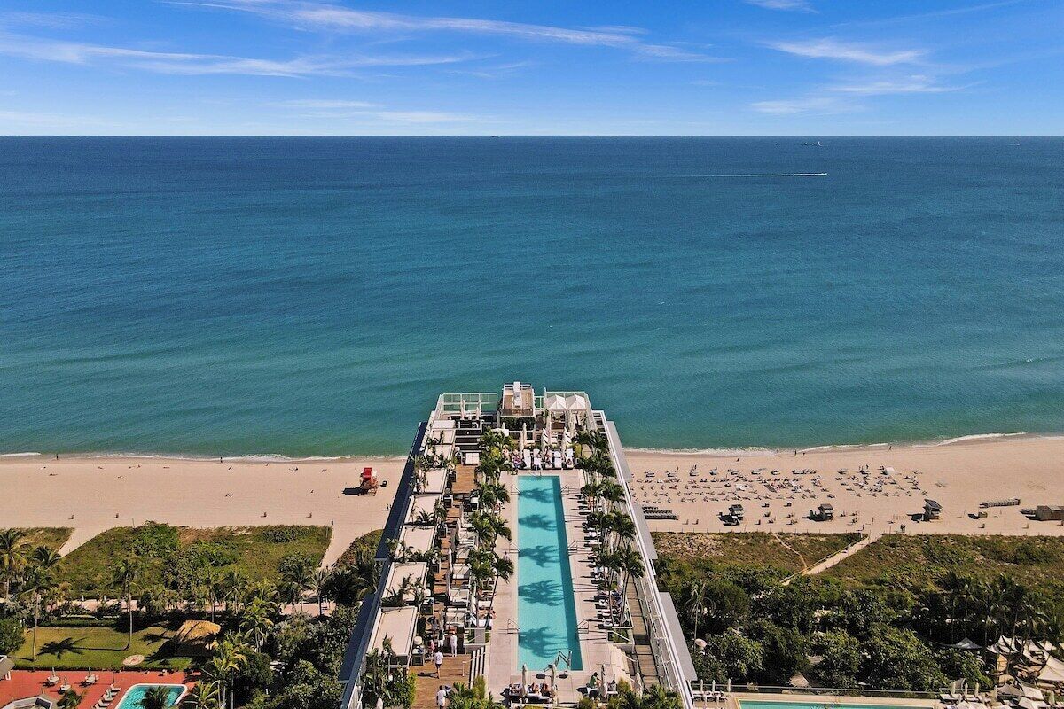 Un complexe hôtelier doté d’une longue piscine, d’un accès à la plage et offrant une vue sur l’océan.