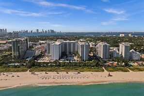 A coastal cityscape with high-rise buildings, a beach, and a distant city skyline. - 1 Hotel South Beach Designer 2BR with Ocean Views (Miami Beach)