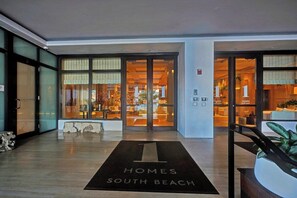 A hotel entrance with a large glass door, a reception desk, and a sign indicating the hotel name. - 1 Hotel South Beach Designer 2BR with Ocean Views (Miami Beach)