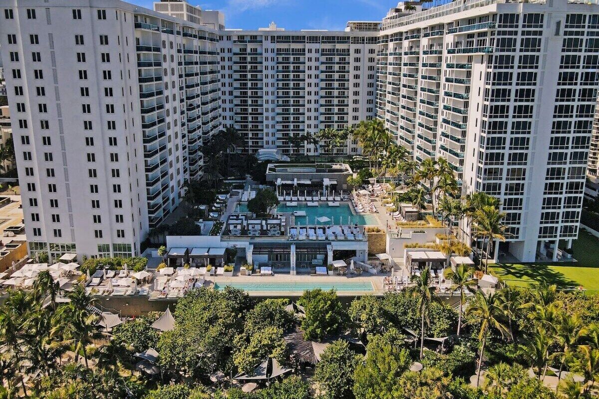 Un hôtel de grande hauteur doté de nombreux balcons, d’une piscine sur le toit et d’une végétation luxuriante.