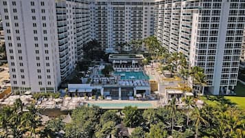 Un hôtel de grande hauteur doté de nombreux balcons, d’une piscine sur le toit et d’une végétation luxuriante.
