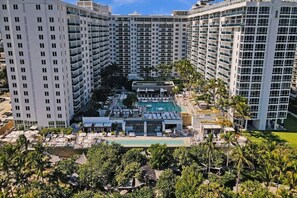 A high-rise hotel with multiple balconies, a rooftop pool, and lush greenery. - 1 Hotel South Beach Designer 2BR with Ocean Views (Miami Beach)