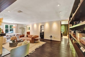 Ein modernes Wohnzimmer mit Sofa, Couchtisch und Bücherregalen.