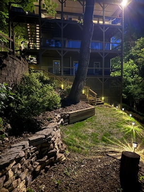 A multi-level outdoor area with stone steps, wooden benches, and a tree.
