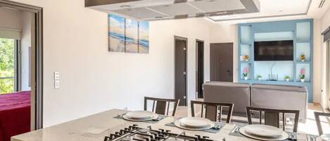 A modern kitchen with a central island, built-in cabinets, and a stainless steel range hood.