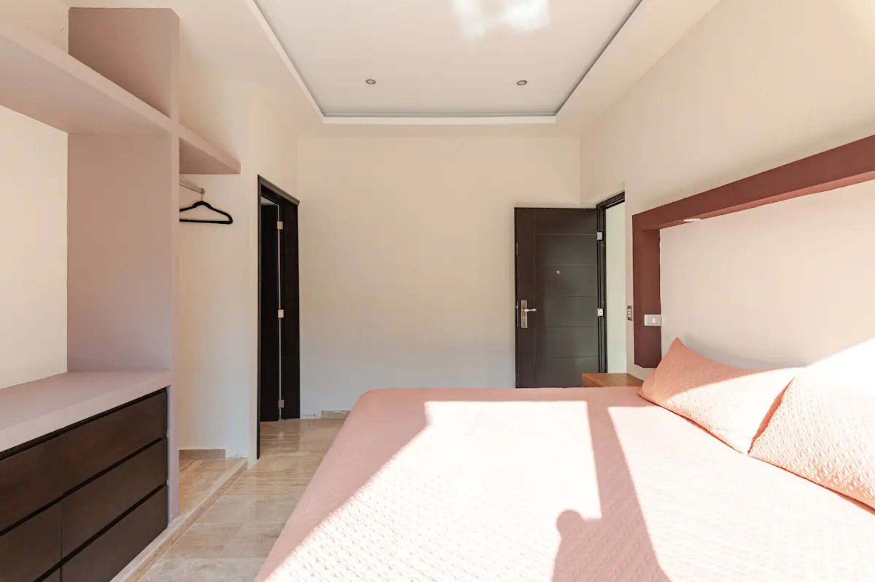 Een slaapkamer met een bed, een kledingkast en een deur.