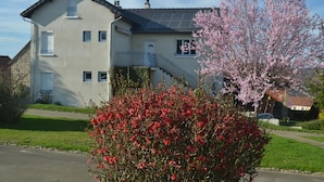 A two-story house with a balcony and solar panels on the roof.