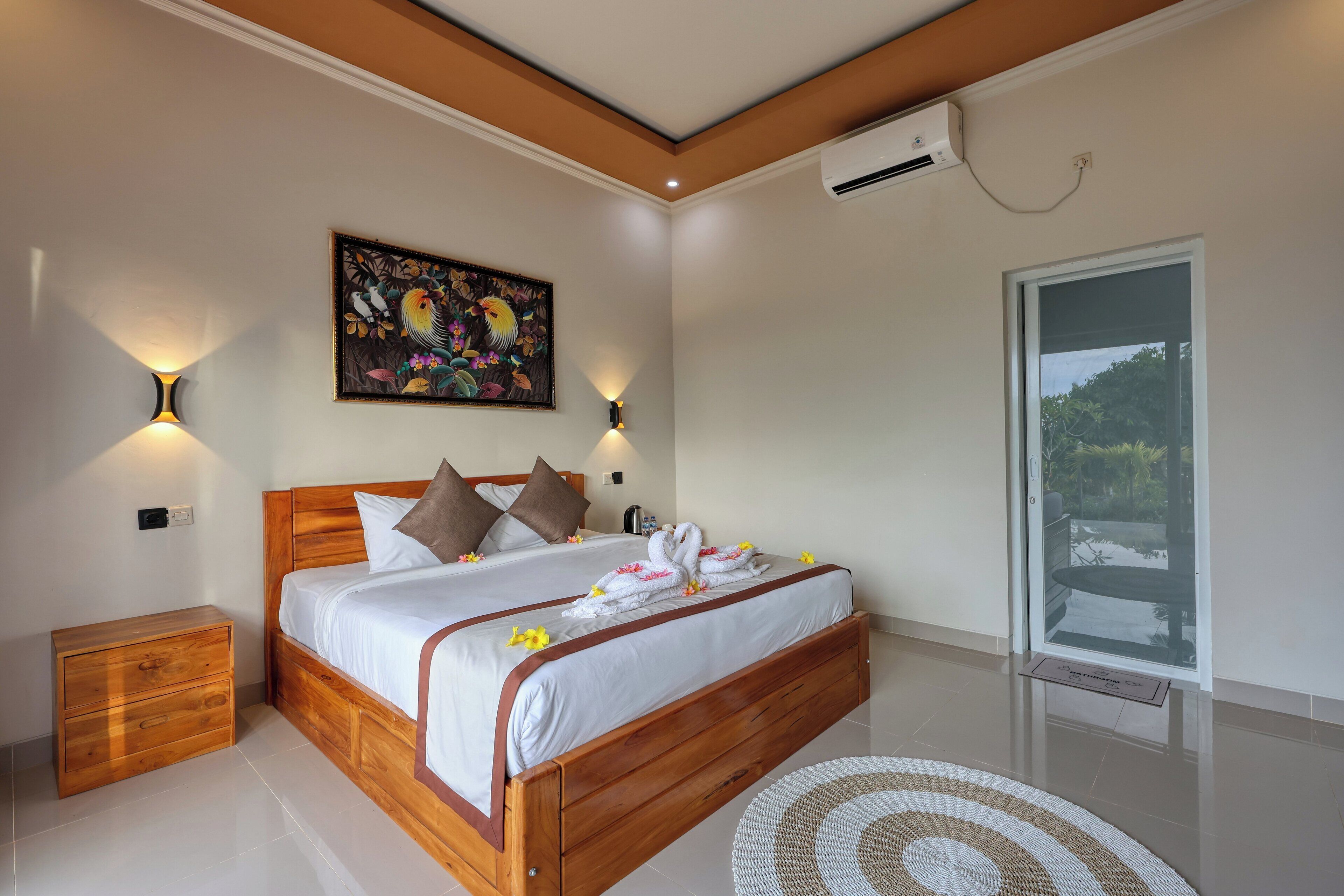 A bedroom with a wooden bed, a nightstand, a wall-mounted air conditioner, and a window with a view.