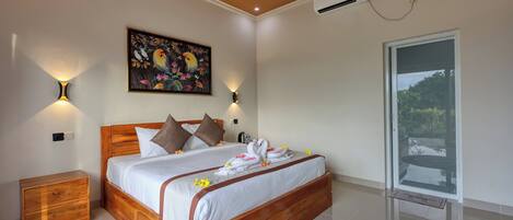 A bedroom with a wooden bed, a nightstand, a wall-mounted air conditioner, and a window with a view.