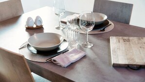 Una mesa puesta con platos, vasos y una servilleta.