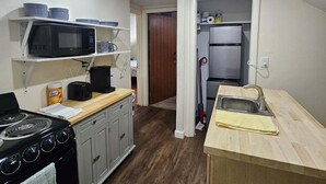 A compact kitchen with a stove, microwave, refrigerator, and a sink. - Nice apartment near Whole Foods, Brown University, Miriam Hospital, Downtown (Providence)