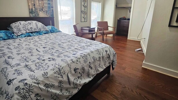 A bedroom with a large bed, a chair, a desk, and a TV mounted on the wall. - Nice apartment near Whole Foods, Brown University, Miriam Hospital, Downtown (Providence)