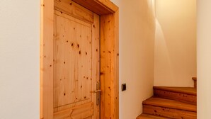 Une porte en bois avec une poignée en laiton et un escalier en bois menant à cette porte.