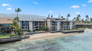 Un hôtel situé en bord de mer, composé de plusieurs bâtiments, doté d’une piscine et donnant sur une plage de sable.