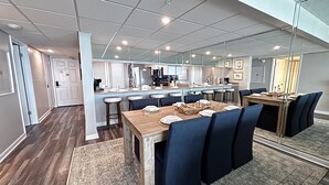 Une cuisine moderne dotée d’un îlot central, de tabourets de bar et d’une table à manger avec des chaises.