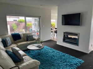 Relax in this stylish living room with a comfortable sofa, flat-screen TV, and fireplace.