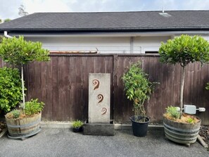 Set amidst lush greenery, this charming home features an entrance with a decorative fence and a beautiful garden.