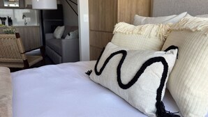 Ein Hotelzimmer mit einem Bett, einem Sessel, einer Couch und einem Holzschrank.