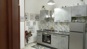 A modern kitchen with marble backsplash, stainless steel appliances, and motivational wall art. - Holiday Home 'Al Castello' with Private Terrace, Wi-Fi and Air Conditioning (Ficarazzi)
