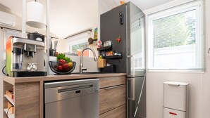 Uma cozinha moderna com lava-louças, frigorífico e pia.