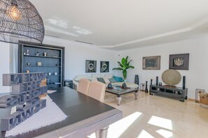 Een moderne woonkamer met een eettafel, bank en decoratieve accessoires.