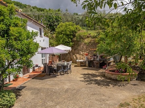 A patio area with outdoor furniture, a table, and a barbecue grill.