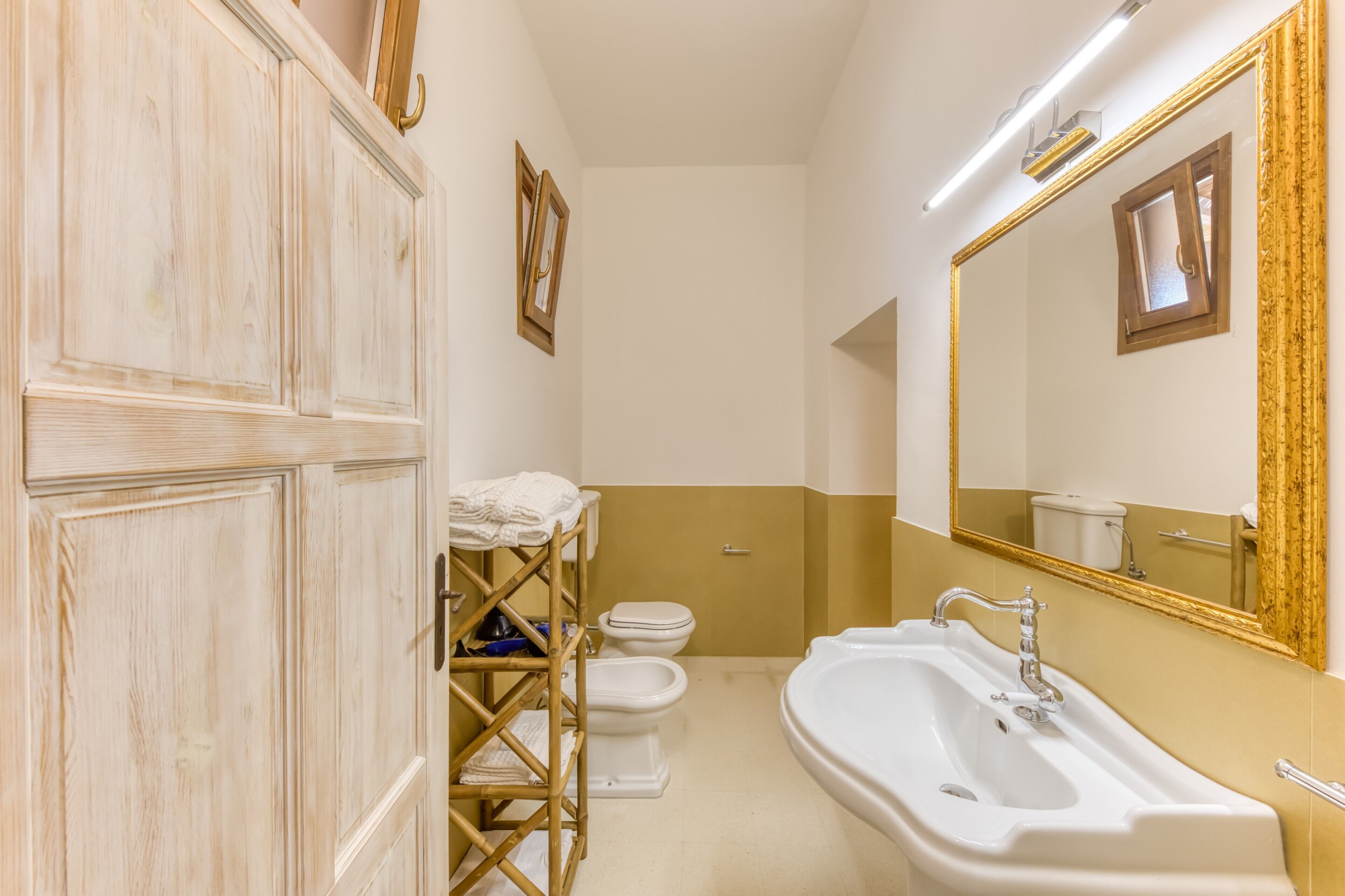 Een badkamer met een wit wastafelmeubel, toilet en douche.