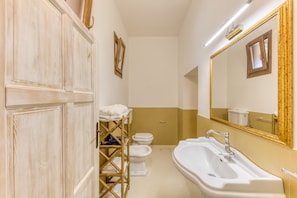 Un baño con lavamanos blanco, inodoro y zona de ducha.