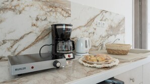 A kitchen with a coffee maker, a kettle, a bread basket, and a microwave. - Apartment 'Double Studio No 9' with Balcony and Wi-Fi (Kalymnos)