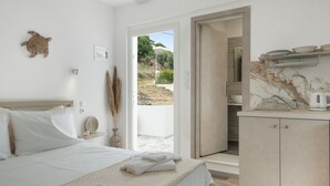 Une chambre avec un lit, une salle de bain avec un lavabo et une vue sur l’extérieur.