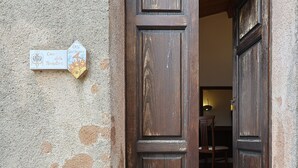 Una puerta de madera rústica con un cartel que indica 'Casa del Pensatore' y 'Case Sant'Andrea'.