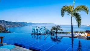 Ein Infinity-Pool mit Blick auf das Meer und die Berge.