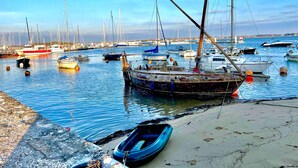 Un port de plaisance avec des bateaux amarrés, une plage de sable et un ciel dégagé.
