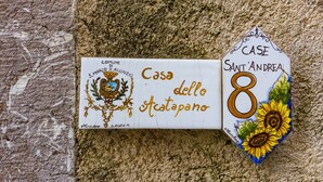 Un cartel con la inscripción 'Casa del Acatapano' y 'Case Sant'Andrea', indicando el nombre y número de la propiedad.