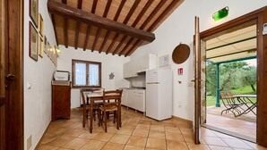 Une cuisine équipée d’une table et de chaises, d’un réfrigérateur et d’une fenêtre.