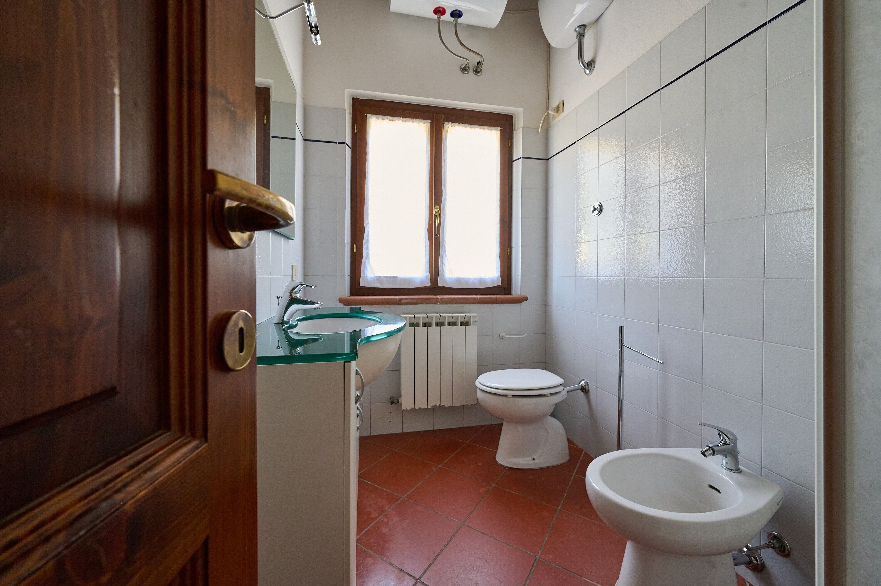 Une salle de bain comprenant des toilettes, un bidet et un lavabo.
