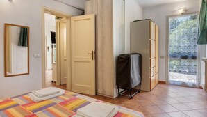 A bedroom with a bed, wardrobe, and a view of the outside. - Holiday Home 'Chiara' with Private Terrace, Wi-Fi and Air Conditioning (Marina di Pietrasanta)
