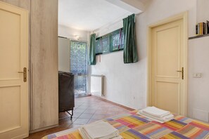 A room with a bed, a radiator, a chair, and a window with curtains. - Holiday Home 'Chiara' with Private Terrace, Wi-Fi and Air Conditioning (Marina di Pietrasanta)