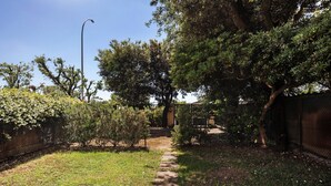 A pathway leading through a garden with trees and a fence. - Holiday Home 'Chiara' with Private Terrace, Wi-Fi and Air Conditioning (Marina di Pietrasanta)