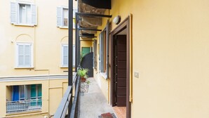 A narrow alleyway with a yellow building, a door, and a small potted plant. - GuestHost - Arco della Pace Apartment Milan (Milan)