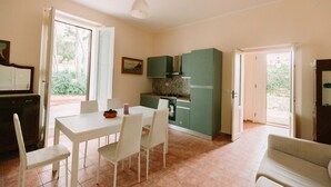 A compact kitchen with a dining area, a built-in stove, and a view through the open door. - GuestHost - Cozy detached villa of 156 sqm, on two levels, able to accommodate up to 9 people. The property is located in Pizzolungo, a coastal hamlet of Erice, an oasis of peace overlooking the crystalline sea of ​​​​western Sicily. A few minute (Pizzolungo)