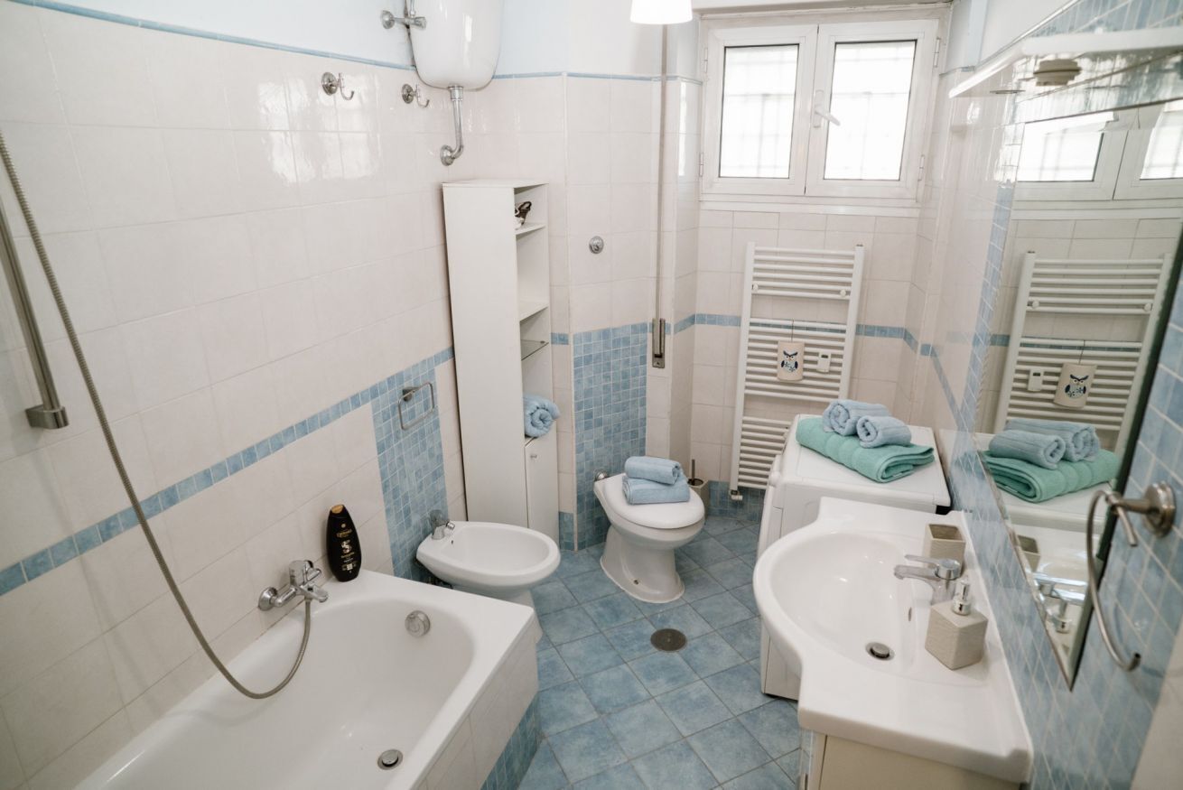 A bathroom with a bathtub, bidet, toilet, and sink.